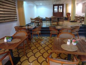 a dining room with wooden tables and chairs at Zeus Paradise Hotel Abuja in Abuja