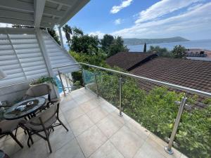 a patio with a table and chairs on a balcony at Apartman Tekoma Herceg Novi in Herceg-Novi
