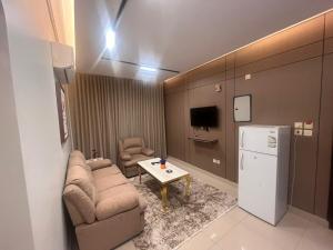 a small living room with a couch and a refrigerator at شقق ضيافه خاصه 5391 in Yanbu