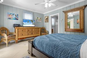 a bedroom with a bed and a tv and a mirror at Prime Downtown Location - Truman Little Cozy Cottage in Key West