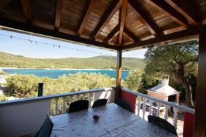 a table on a balcony with a view of a lake at House Punta in Kraj