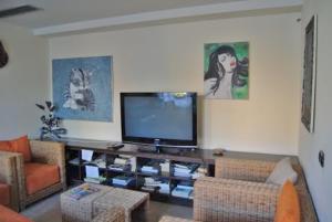 sala de estar con TV de pantalla plana y muebles en Hotel Europa, en San Bartolomeo al Mare