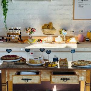 a table topped with lots of different types of food at Chalés Vila do Moinho in Monte Verde