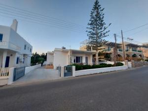 a street with houses and a tree on the side of the road at Araucaria Beachfront Residence in Finikas