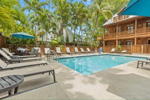 a swimming pool with lounge chairs and a house at Orchid Bay Condo - Pool - Old Town - Walk to Duval in Key West