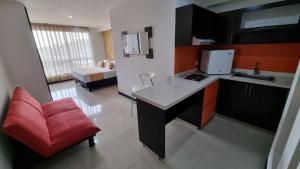 a kitchen with a desk and a red chair in a room at Hotel Mare Apartasuite in Cali +22 photos