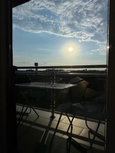 a table and chairs on a balcony with the sunset at LUMA Campus Studio in Brčko