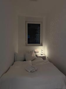 a white bedroom with a white bed with a window at LUMA Campus Studio in Brčko