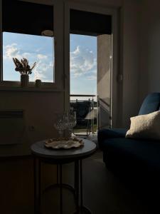 a living room with a table and a blue couch at LUMA Campus Studio in Brčko