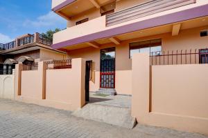 a house with a gate in front of it at Super Hotel O Dharampur Crossway in Mājra
