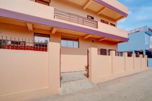 a house with a fence in front of it at Super Hotel O Dharampur Crossway in Mājra