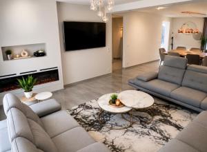 a living room with two couches and a fireplace at Villa luxueuse et Moderne avec piscine ! in Béziers