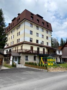 a large white building with a brown roof at Apartman RAJAN Vlašić in Vlasic