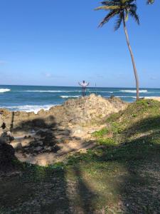 a person standing on top of a rock near the ocean at Rancho La Cueva in Miches
