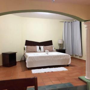 a bedroom with a large white bed and a window at Rancho La Cueva in Miches