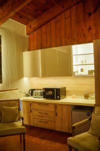 a kitchen with a counter with a microwave and a chair at Valea Bhurban in Bhurban
