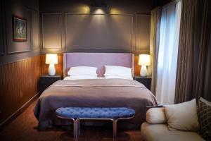 a bedroom with a large bed with a blue bench at Valea Bhurban in Bhurban