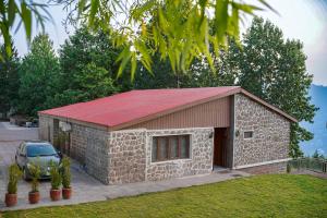 a small stone building with a red roof at Valea Bhurban in Bhurban