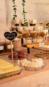 a table filled with cheese and other food items at Chalés Vila do Moinho in Monte Verde