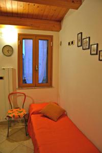 a bedroom with a bed and a chair and a window at Giardino Del Sole in Taormina