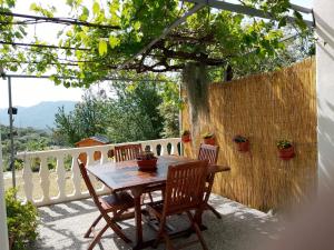 a table and chairs on a patio with a fence at Serendipity in Arnasco