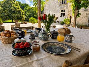 a table with plates of food and a bowl of fruit at Château de Bagneux in Bournan