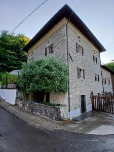 an old stone building with a black roof at Eva house 1 in Fanano