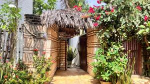 an entrance to a house with flowers and plants at Pousada Jangá Jeri in Jericoacoara