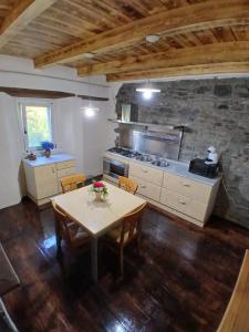 a kitchen with a table with chairs and a stove at Eva house 1 in Fanano