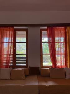 a couch in a living room with two windows at Casa Kaikos in Sevastí