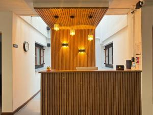 a lobby with a counter with a clock and lights at Hostal Casa Iwa in Medellín