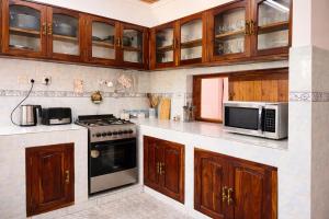 a kitchen with a stove and a microwave at Toiwo Residence 4BR Home in Ilboru, Arusha in Arusha