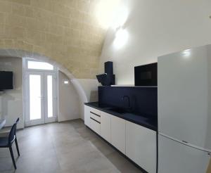 a kitchen with white cabinets and a black counter top at Radici 1892 in Montescaglioso