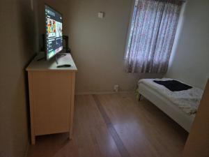 a bedroom with a desk with a computer monitor on it at God søvn in Lillestrøm