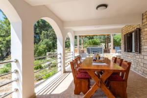 a dining room with a table and chairs on a balcony at Villa Franciska in Blato