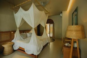 a bedroom with a canopy bed with nets on it at Schönhouse Villa Siargao in General Luna +39 photos