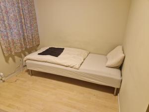 a small bed in a small room with a window at God søvn in Lillestrøm