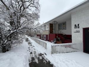a house covered in snow with a fence at Merlot House in Calgary