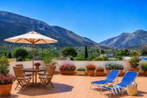 eine Terrasse mit Tisch, Stühlen und Sonnenschirm in der Unterkunft Grimaldi B&B in San Vito lo Capo