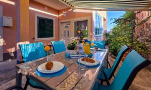 a table with plates of food on top at Mendy Sea View Apartment in Kaštela