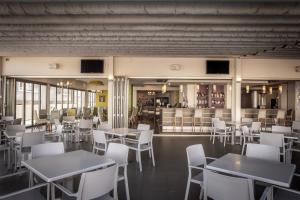 a restaurant with white tables and white chairs at Euronapa Hotel in Ayia Napa