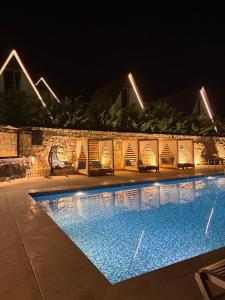 a swimming pool at night with lights on it at Valdiz in Zahlé