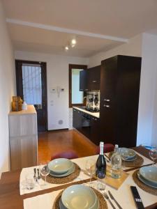 a kitchen with a table with plates and wine glasses at La Tana - Borno Holiday in Borno