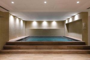 a large swimming pool in a room with at Hotel Gaivota Azores in Ponta Delgada