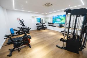 a gym with tread machines and a large screen at Hotel Gaivota Azores in Ponta Delgada