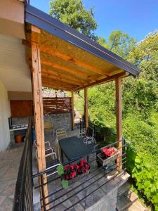 a patio with a roof with a table and flowers at Villa D&M in Ohrid