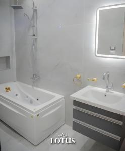 a white bathroom with a tub and a sink at Lotus Hotel l Downtown Cairo Sq in Cairo