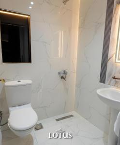 a white bathroom with a toilet and a sink at Lotus Hotel l Downtown Cairo Sq in Cairo +34 photos