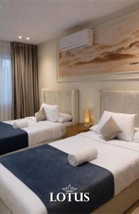 two beds in a hotel room with a hotel sign on them at Lotus Hotel l Downtown Cairo Sq in Cairo