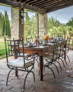 a wooden table with chairs around it on a patio at Chianti Escape PoolVines Tenuta Bibbiano-I Sodi in Castellina in Chianti